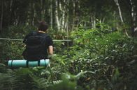 Man in Black T-shirt and Blue Denim Jeans Sitting on Green Grass