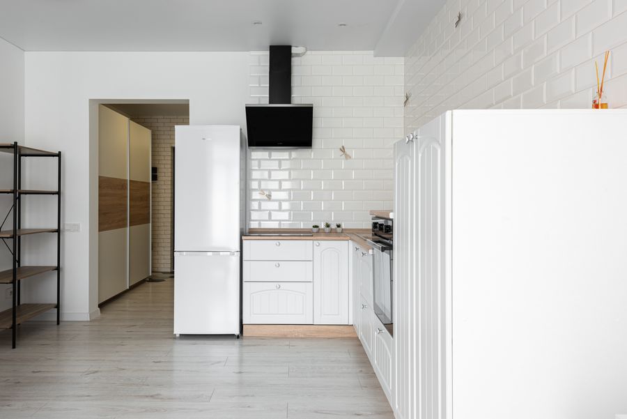 Modern kitchen refrigerator beside cabinets