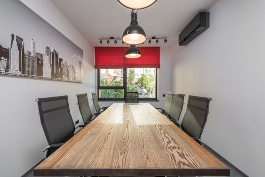 Contemporary workspace interior with photo of city against lamps over desk and armchairs in daytime