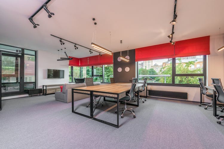 Modern Office Interior With Furniture And Lamps Against Windows