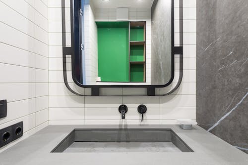 Contemporary bathroom interior with mirror above washbasin at home