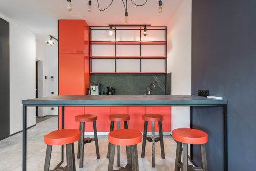 Free Contemporary kitchen with table and chandelier against empty shelves above coffee machine in light house Stock Photo