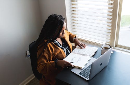 Businesswoman Looking at Stationery in front of Laptop