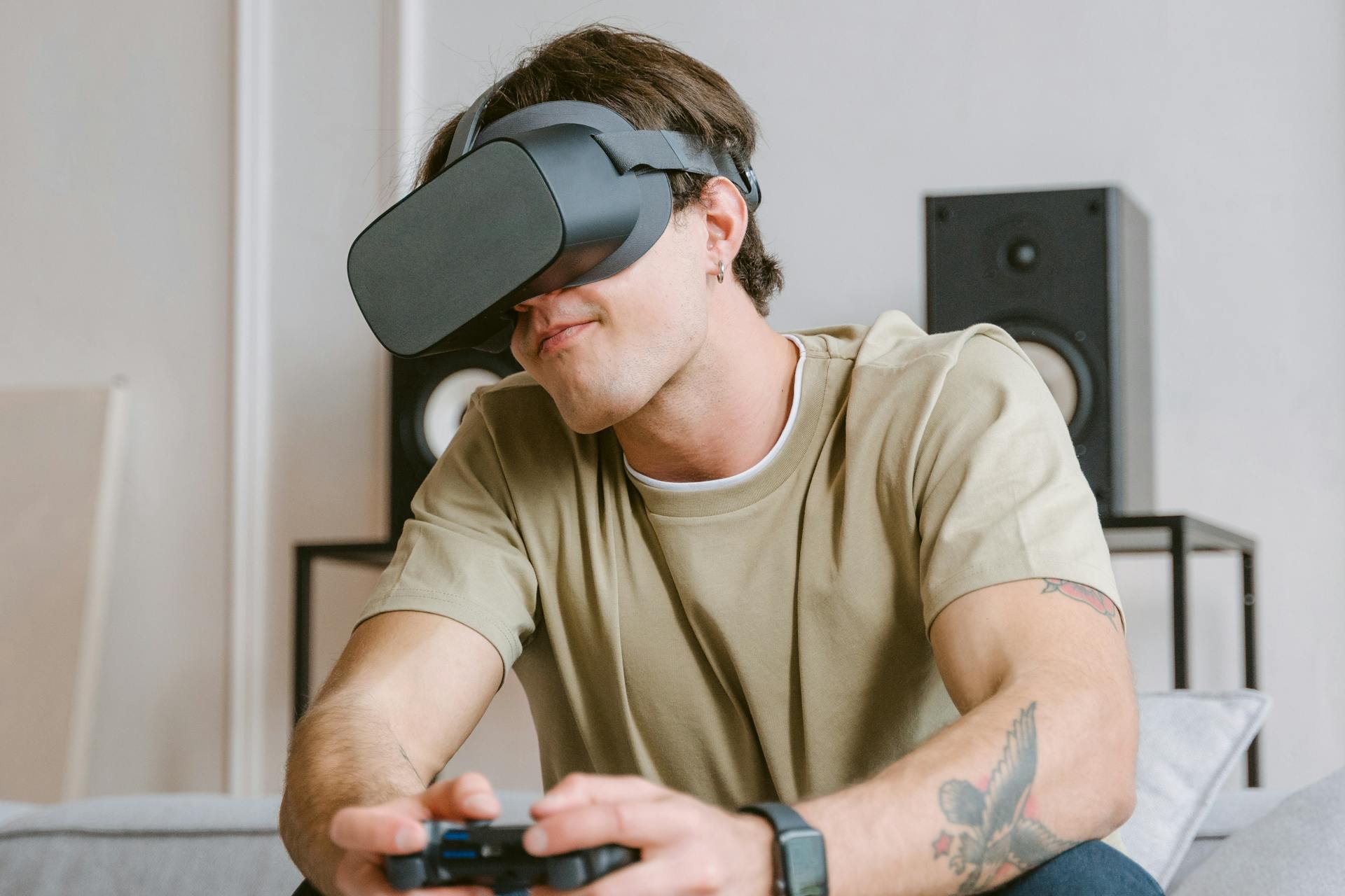 Young man playing video games using VR headset indoors, symbolizing modern technology entertainment.