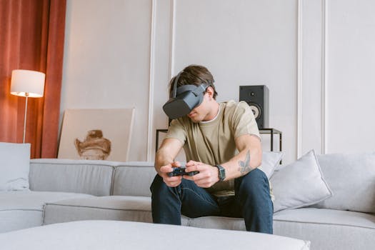 A young man enjoying virtual reality gaming on a couch at home, wearing a VR headset.