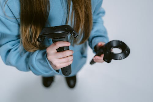 Close-Up Photo of Person Holding VR Controllers