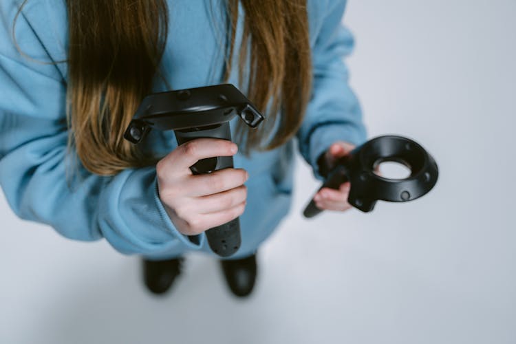 Close-Up Photo Of Person Holding VR Controllers