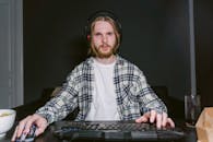 Man in Plaid Shirt Playing a Video Game