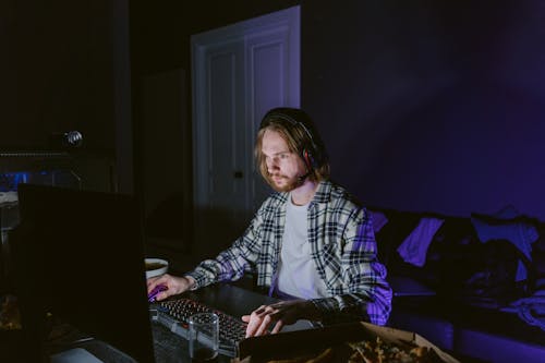 Free Man in Plaid Shirt Playing a Computer Video Game Stock Photo