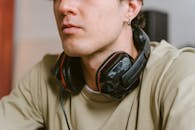 Man in Brown Crew Neck Shirt Wearing Black and Red Headphones