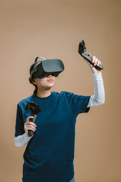 Free A Person in Blue Shirt Playing a Virtual Reality Video Game Stock Photo