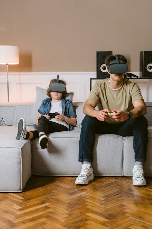 A Man and Boy Sitting on a Couch while Playing a Virtual Reality Video Game