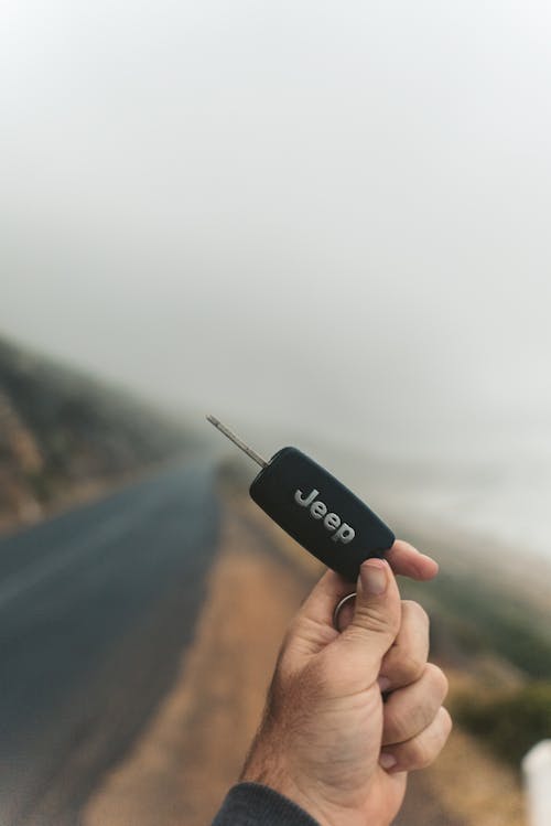 Shallow Focus Photo of a Person Holding a Black Jeep Car Key