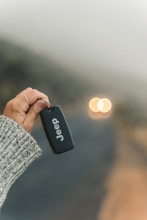 Shallow Focus Photo of a Person Holding a Black Jeep Car Key