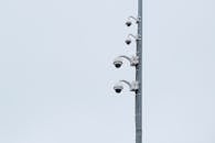 Security Cameras on Metal Pole Under White Sky