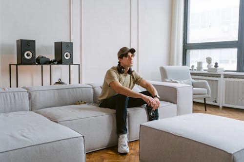 A Man Wearing a Cap while Sitting on the Couch