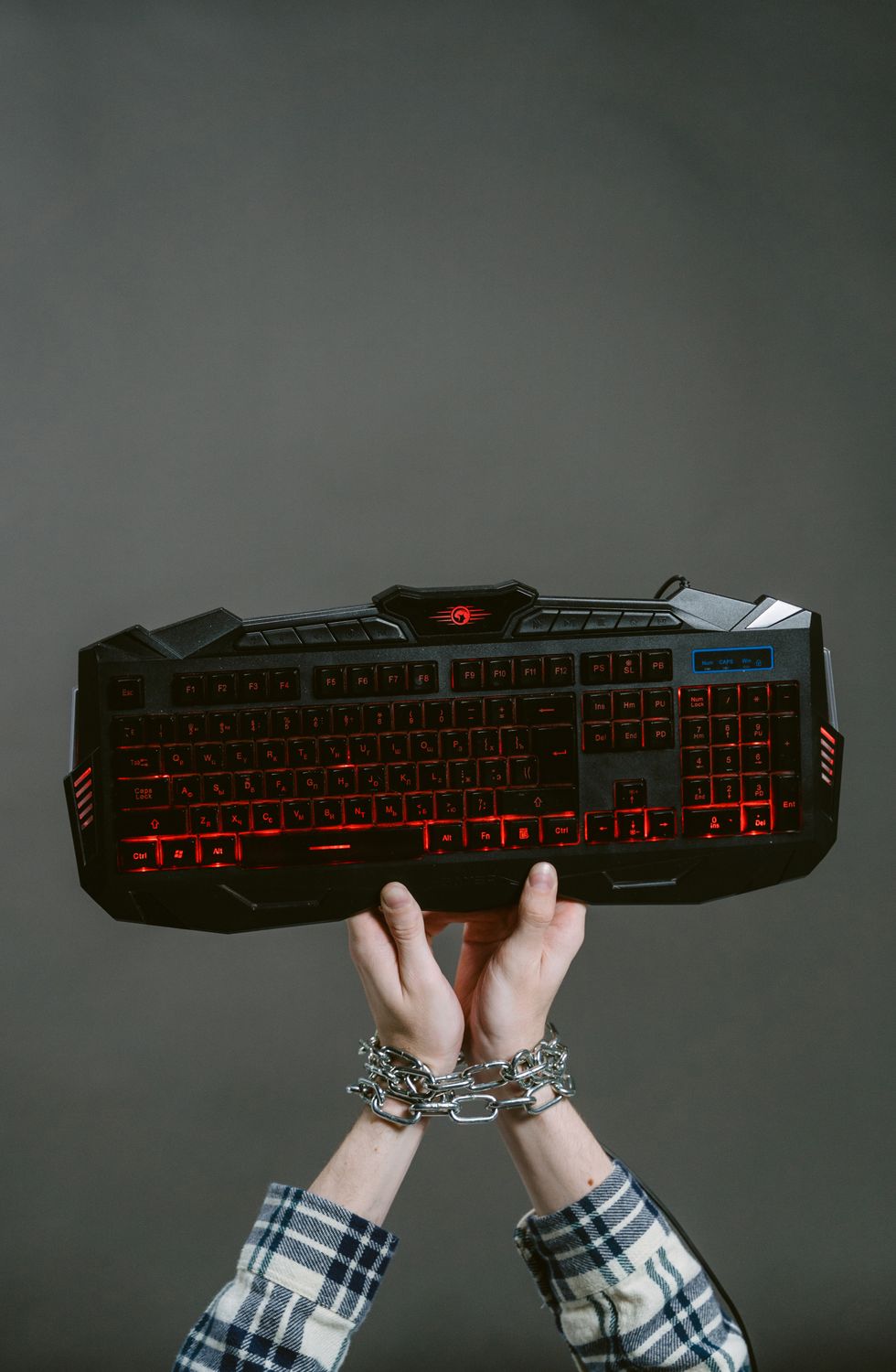 A Chained Hands Holding a Computer Keyboard · Free Stock Photo