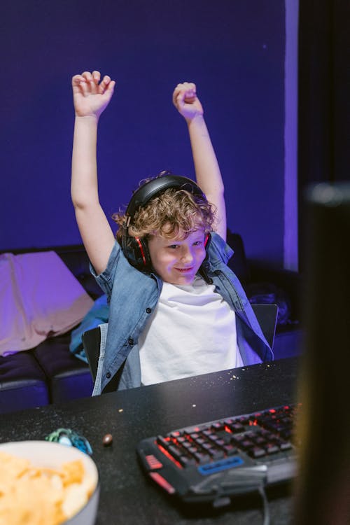 A Boy Sitting in  Front of a Computer Winning a Computer Game