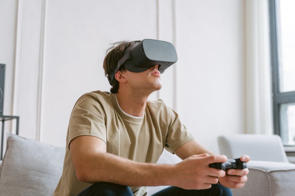 Adult man immersed in VR gaming with headset and controller indoors.