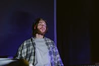 A Man in Black and White Plaid Dress Shirt Wearing Headphones