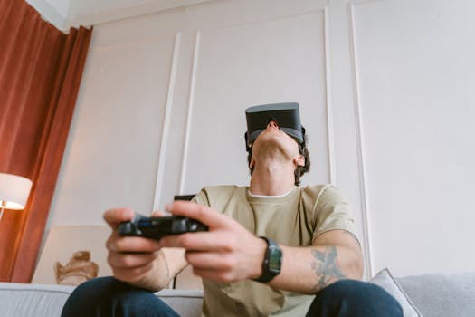 An adult male intensely gaming with a VR headset and controller indoors.
