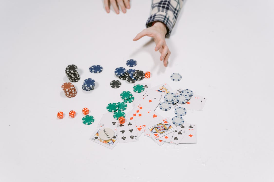 Free Close-Up Shot of Poker Chips and Playing Cards on a White Surface Stock Photo