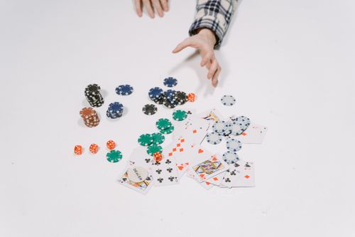 Free Close-up of poker chips and cards on a white surface, capturing a moment in a card game. Stock Photo