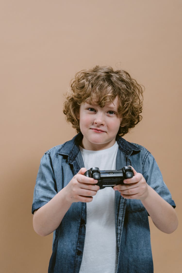 A Boy Holding A Gaming Controller