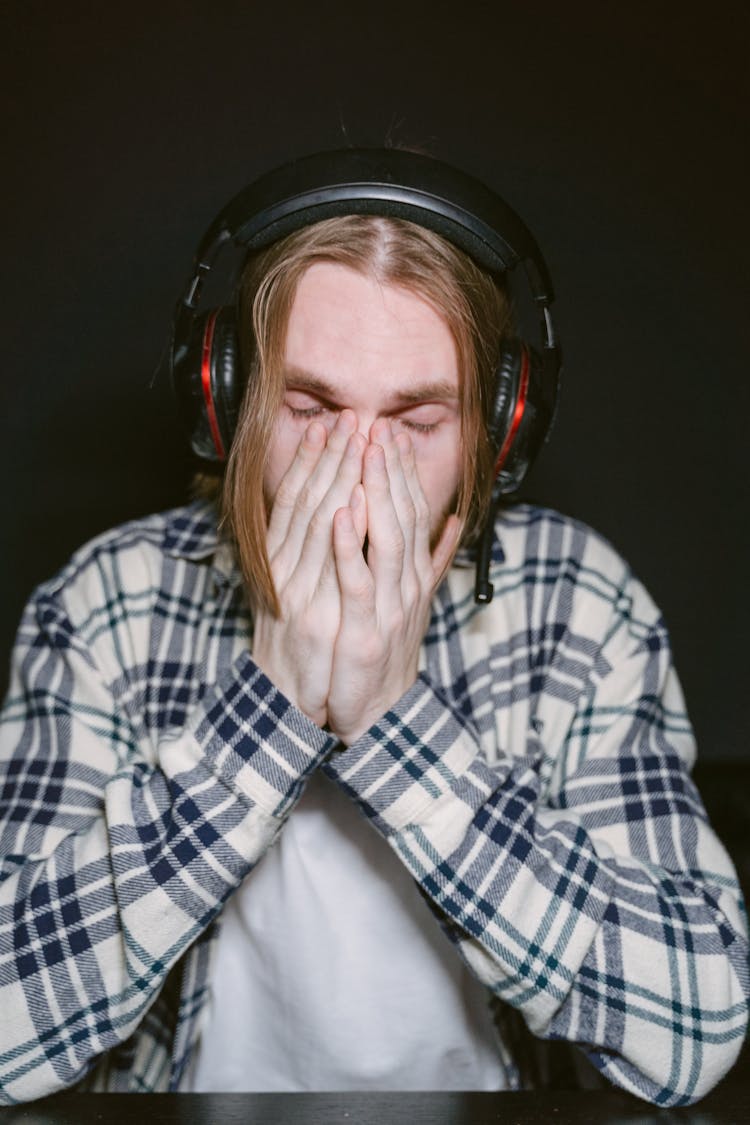 Close-Up Shot Of A Person In Checkered Long Sleeves Wearing Headphones