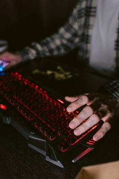 Close-up of hands using backlit mechanical keyboard, ideal for gaming and technology themes.