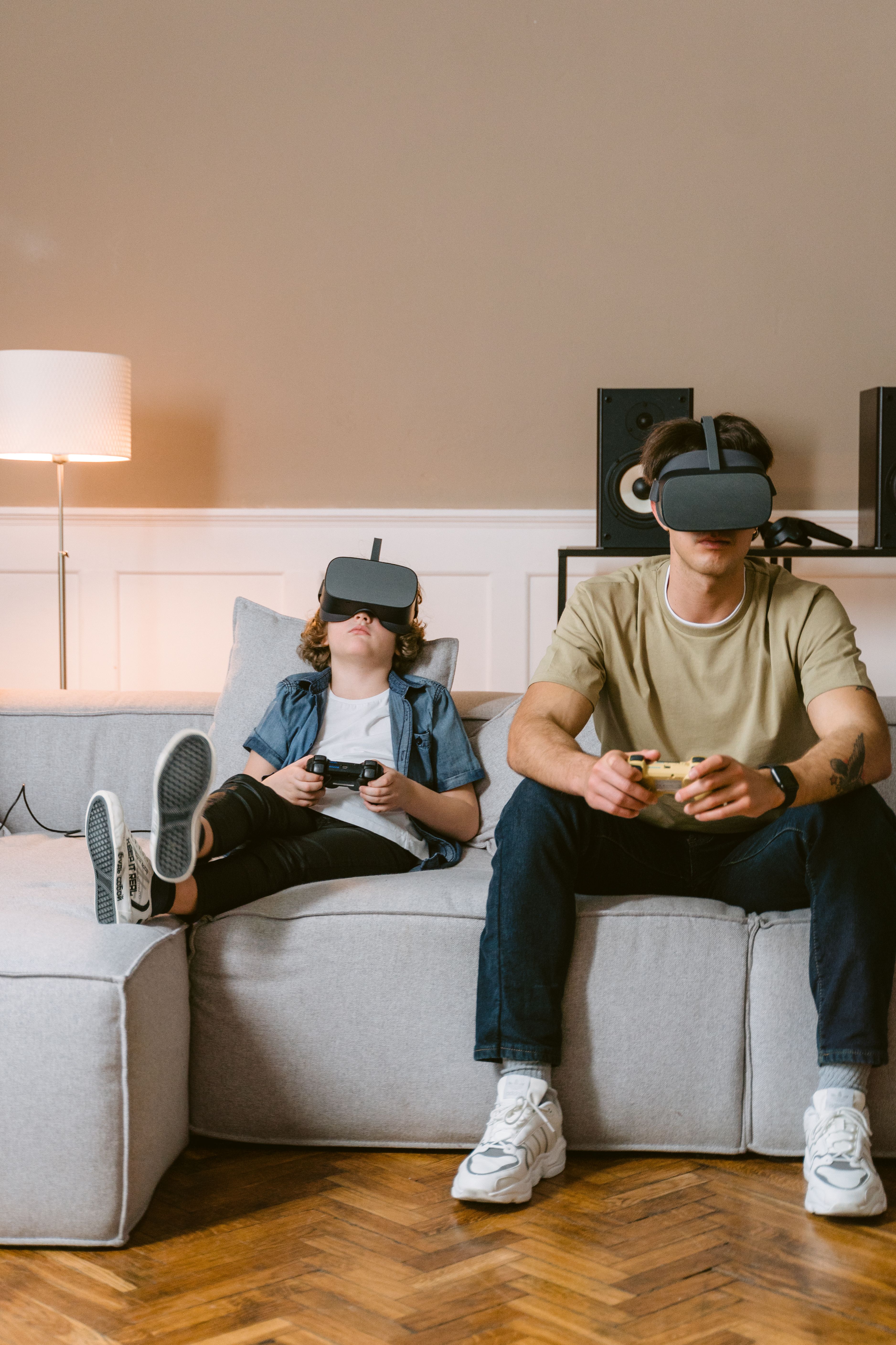 A Man and Boy Sitting on a Couch while Playing a Virtual Reality Video ...