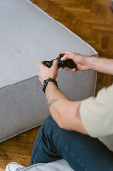 Adult male enjoying video gaming at home with a console controller.