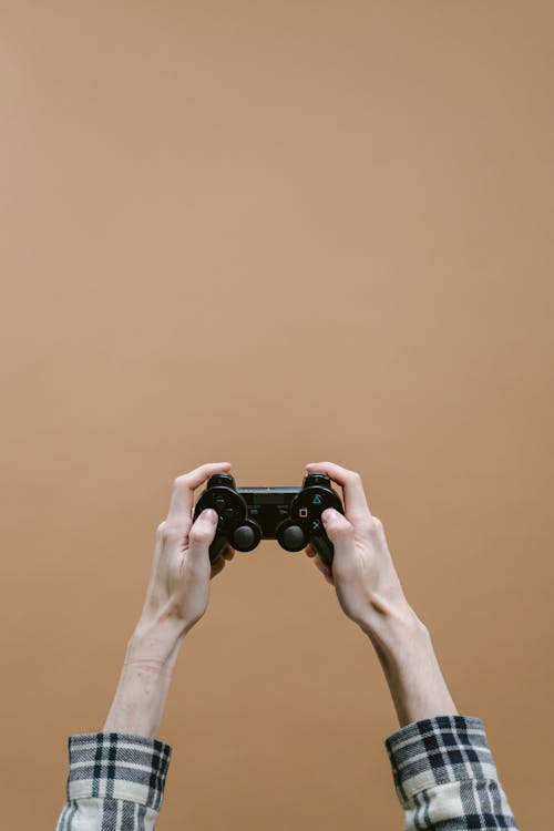 Foto profissional grátis de console de videogame, fundo marrom, gamer
