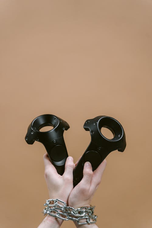 Person Holding Black Game Controllers