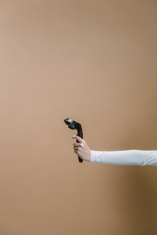 A Person in White Long Sleeves Holding a Game Controller