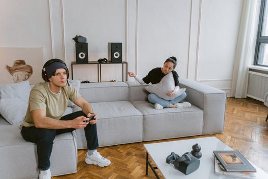 Young adults enjoying video gaming and relaxation in a stylish living room.