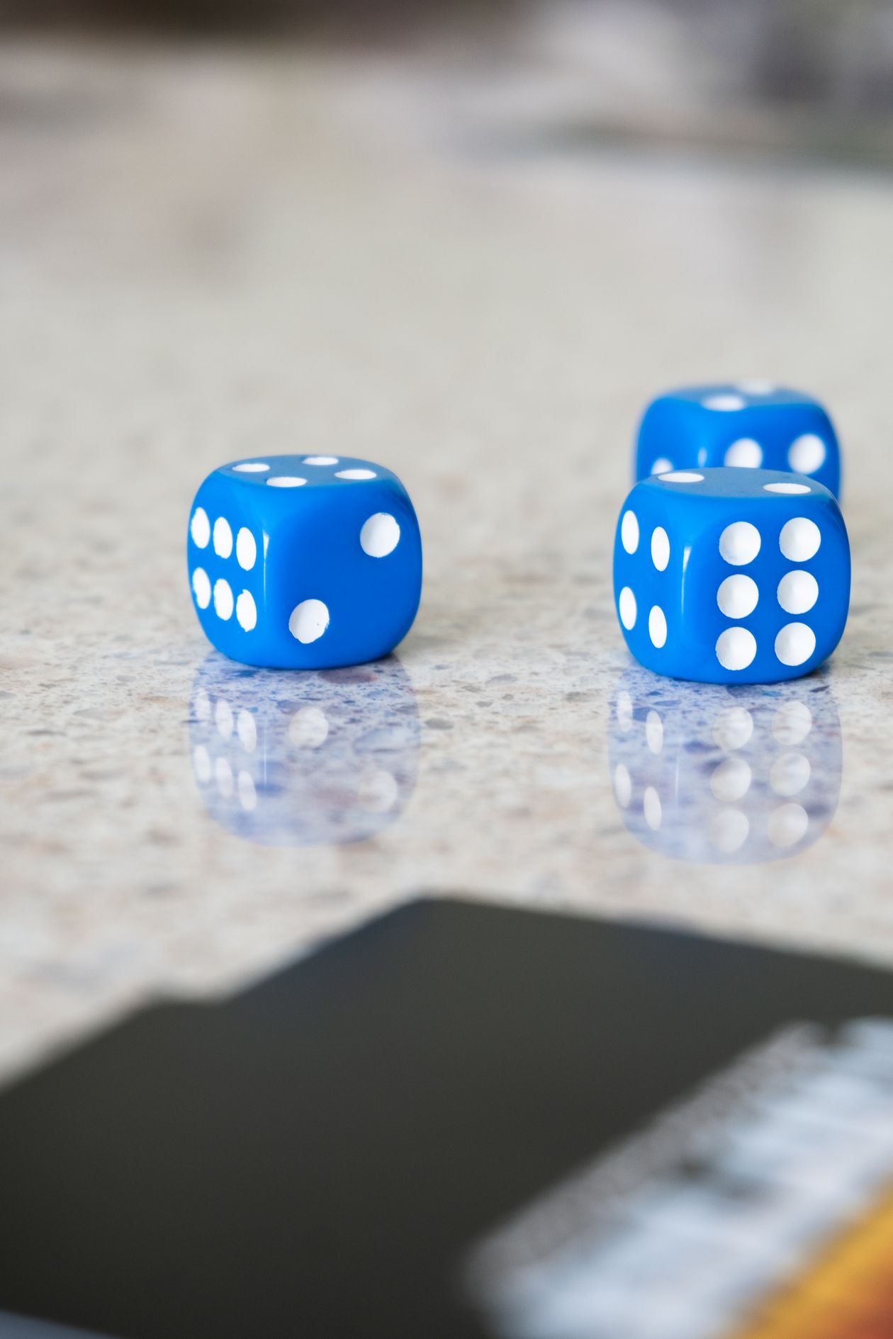 D&D's World of Warcraft Book Lands Twice: November 3 and November 17 Three blue six-sided dice on a reflective marble surface
