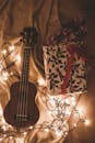 温馨的节日场景中，四弦琴与节日礼物点缀其间，四周环绕着童话般的灯光