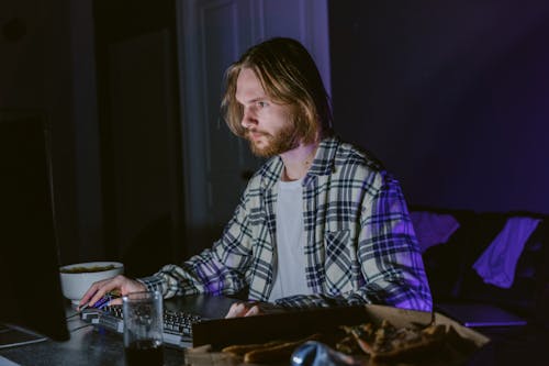 A Man Sitting at a Table Using a Computer