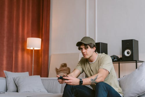 Man in Crew Neck T-shirt and Blue Denim Jeans Sitting on a Sofa