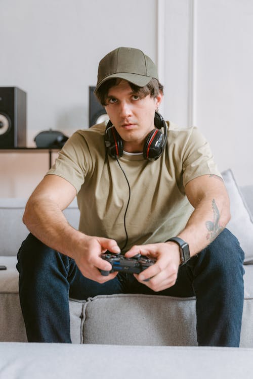 A Man Playing Video Games while Sitting on a Sofa