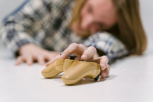 Hand reaching out to touch a yellow game controller, focus on interaction.