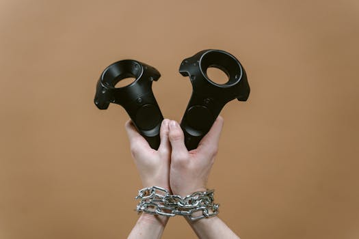 A close-up of hands in chains holding VR controllers against a brown background.