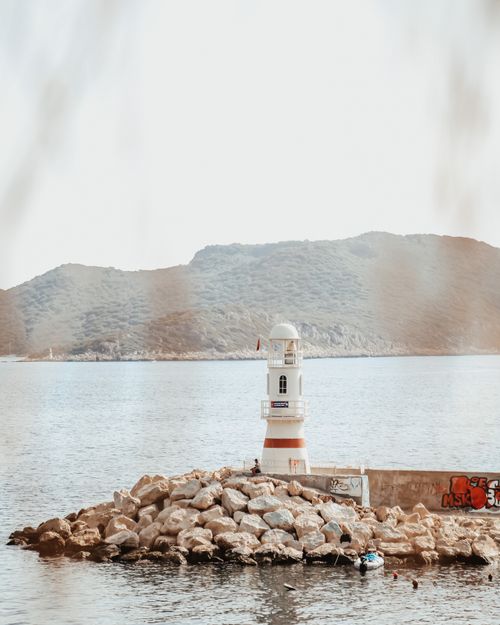 Free Scenic view of a lighthouse with rocky coast and calm sea, perfect for relaxation themes. Stock Photo