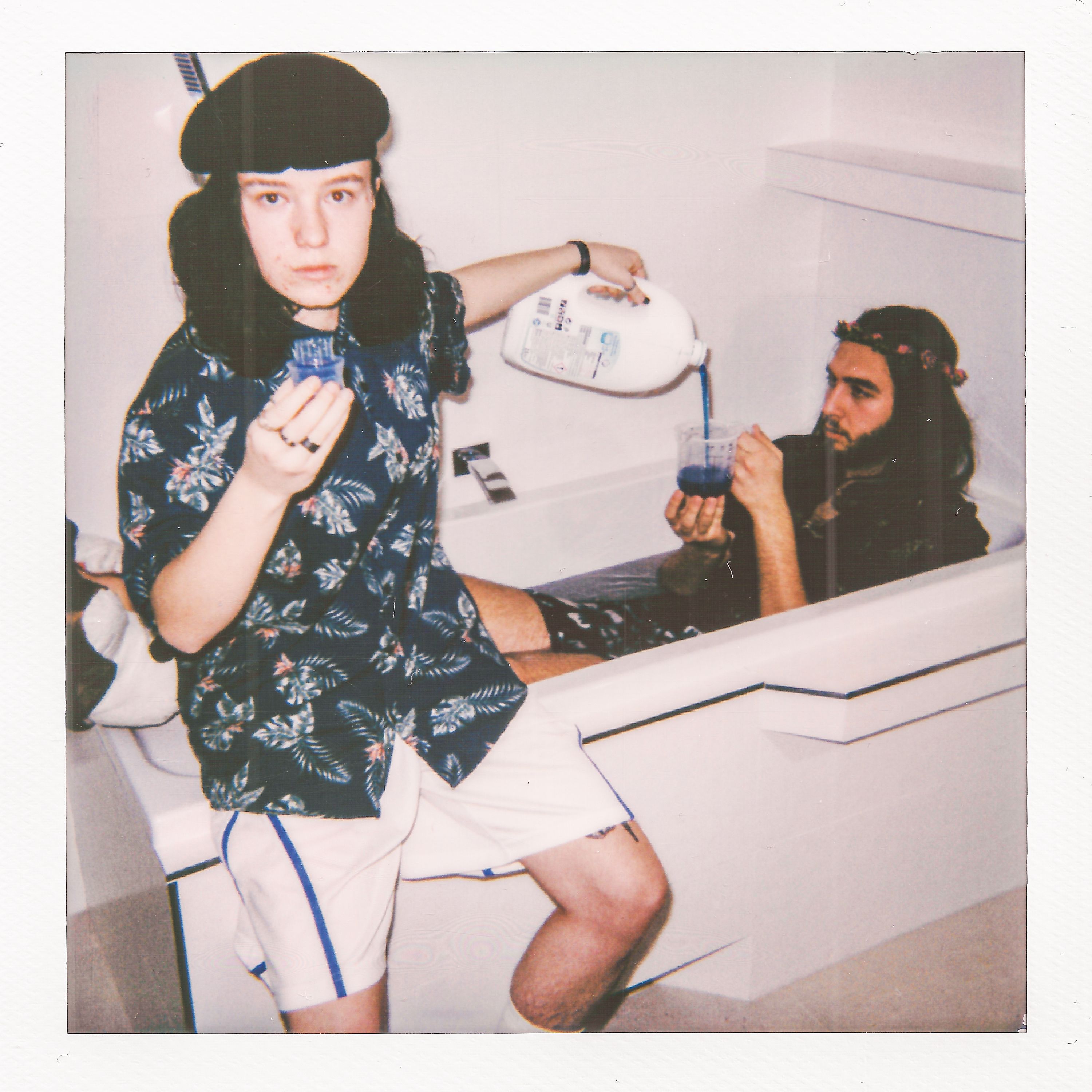 A Polaroid Picture of a Man Pouring Detergent to a Plastic Container