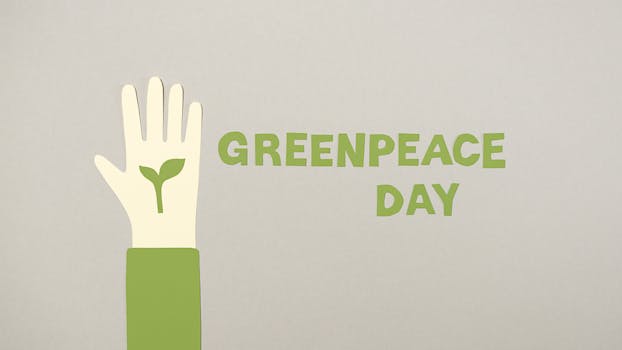 Illustrative Greenpeace Day poster featuring a hand symbolizing environmental conservation.