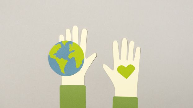 Creative paper cutout depicting environmental protection with Earth and heart symbols.