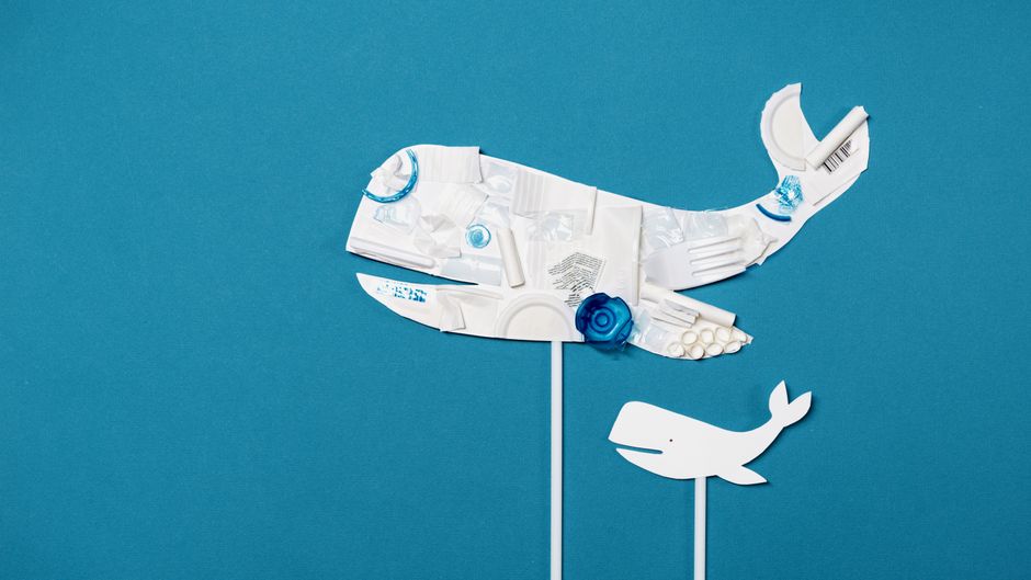 Conceptual image of a whale shape made from recycled plastic on a bright blue background.
