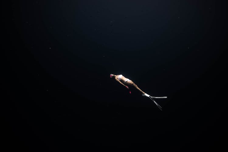 Athletic Woman In Flippers Swimming Under Water