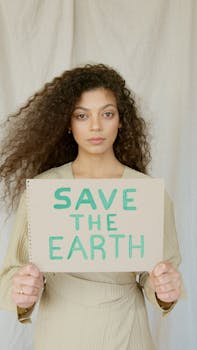 Portrait of a woman promoting environmental awareness with a handmade sign.